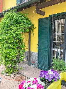 a green door and flowers in front of a building at La Villa di Bambi in Vanzago