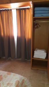a bedroom with a bed and a shelf with towels at Departamento San Rafael - Sobre Paseo Chile in San Rafael