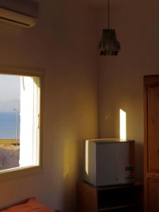 a room with a tv and a window and a bed at Nook seaview in Dahab