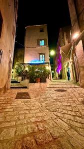 an empty street at night with a building at Colomba Hôtel Centre-Ville Historique in Bonifacio