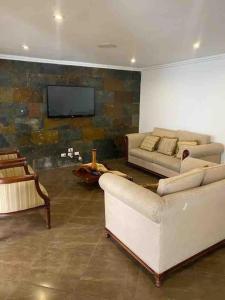 sala de estar con sofás y TV de pantalla plana. en Departamento entero sector Oro Verde en Cuenca