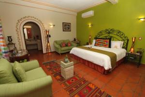 een slaapkamer met een groot bed en groene muren bij Hotel Boutique Parador San Miguel Oaxaca in Oaxaca City