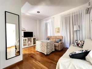 un salon avec un canapé et un miroir dans l'établissement Apartamento muy céntrico en Granada, à Grenade