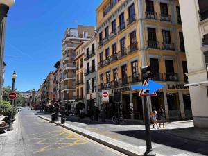 une rue de la ville avec des bâtiments et une flèche bleue dans l'établissement Apartamento muy céntrico en Granada, à Grenade