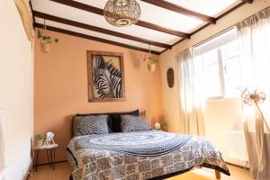 a bedroom with a bed with a zebra picture on the wall at Gezellig ruim landelijk huisje aan het water in Spijkenisse