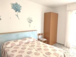 1 dormitorio con 1 cama con una flor en la pared en CASA FRONTE MARE, en Ventimiglia