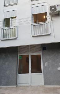 a white building with a door and a balcony at Apartman Mila in Split