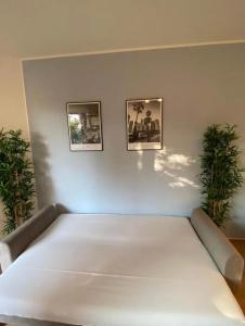 a white bed with two pictures on a wall at Zentraler Komforttraum in Berlin