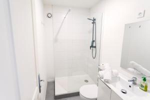 a white bathroom with a shower and a toilet at Suite 1 &2 Joubert de Lily in Villiers-sur-Marne