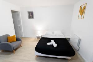 a bedroom with a large bed and a chair at Suite 1 &2 Joubert de Lily in Villiers-sur-Marne