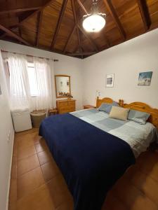 ein Schlafzimmer mit einem großen Bett mit einer blauen Decke in der Unterkunft VV Casa Carmela Talavera in Barlovento