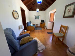 ein Wohnzimmer mit einem blauen Sofa und einem Stuhl in der Unterkunft VV Casa Carmela Talavera in Barlovento