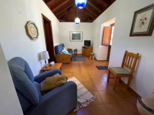 een woonkamer met een blauwe bank en een stoel bij VV Casa Carmela Talavera in Barlovento