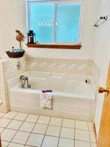 baño con bañera blanca y ventana en Urban Farmhouse- KING bed!, en Corvallis