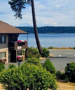 a house with a balcony with flowers on it next to a lake at Ramada by Wyndham Campbell River in Campbell River