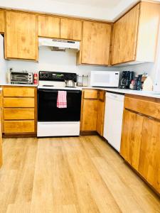 cocina con armarios de madera y horno blanco y negro en Urban Farmhouse- KING bed!, en Corvallis