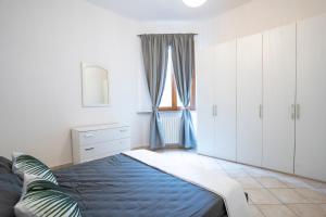 1 dormitorio con cama, armarios blancos y ventana en Appartamenti moderni Empoli-Vinci, en Empoli