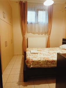 sypialnia z łóżkiem i oknem w obiekcie New Village apartment w Chios