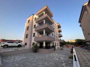 a building with a car parked in front of it at Apartments Ivana in Sveti Filip i Jakov