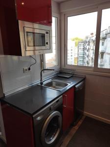 una cucina con lavandino e lavatrice di Amonaren Etxea. a San Sebastián