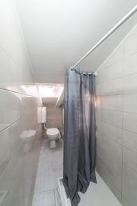a bathroom with a toilet and a shower curtain at City Center Mayess Aparment in Zadar