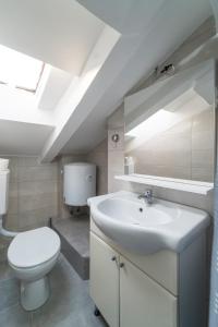 a bathroom with a white sink and a toilet at City Center Mayess Aparment in Zadar