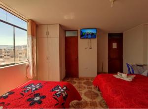 a bedroom with a red bed and a large window at Hotel San Francisco in Cajamarca