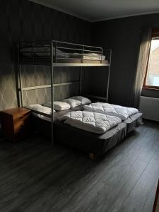 a bedroom with two bunk beds and a wooden floor at Vetlandavägen 37 C in Målilla