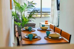 a table with plates and cups on top of it at Ocean View Penthouse in Playa de las Americas