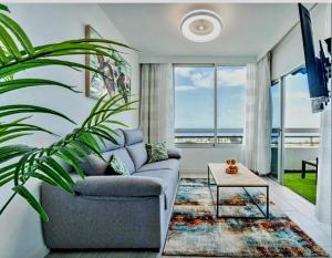 uma sala de estar com um sofá e uma mesa em Ocean View Penthouse em Playa de las Americas