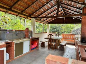Una cocina al aire libre con una mesa y un fregadero. en Sítio incrível 4Q c/ piscina e área de churrasco, en Vítor Hugo