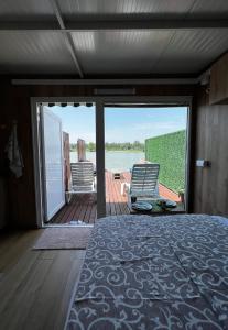 Schlafzimmer mit einem Bett und Blick auf das Wasser in der Unterkunft Splav na reci Savi in Ostružnica