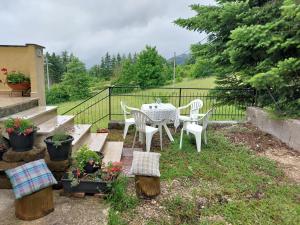 eine Terrasse mit einem Tisch, Stühlen und Pflanzen in der Unterkunft Un angolo di tranquillità 