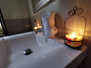 a bathroom sink with a candle in a glass jar at Casa El Cipres Residencial Privada in Santo Tomás