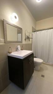 a bathroom with a sink and a toilet and a mirror at Casa El Cipres Residencial Privada in Santo Tomás