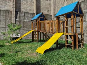a playground with a slide in the grass at Casa El Cipres Residencial Privada in Santo Tomás