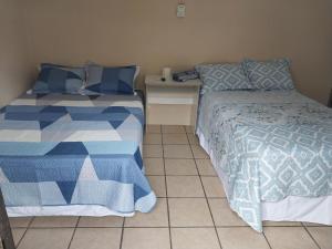 sypialnia z 2 łóżkami i podłogą wyłożoną kafelkami w obiekcie Hostal San José w mieście La Unión