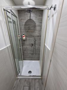 y baño con ducha y puerta de cristal. en Suites Caracciolo, en Nápoles