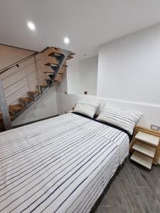 1 dormitorio con 2 camas y escalera en Suites Caracciolo, en Nápoles