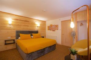 a bedroom with a bed with yellow pillows at Shenstone Lodge in Kidderminster
