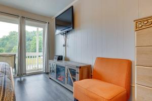een woonkamer met een oranje stoel en een tv bij Fayetteville Vacation Rental with Balcony! in Fayetteville