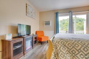 ein Schlafzimmer mit einem Bett, einem TV und einem Stuhl in der Unterkunft Inviting New River Gorge Studio! in Fayetteville