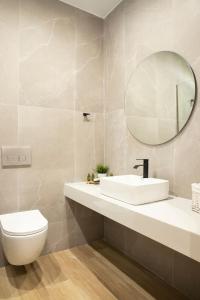 a bathroom with a sink and a toilet and a mirror at Olympus Suites in Paralia Panteleimonos +68 photos