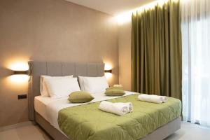 a bedroom with a large bed with towels on it at Olympus Suites in Paralia Panteleimonos