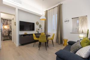 a living room with a couch and a table with yellow chairs at SolferinoNove in Rome