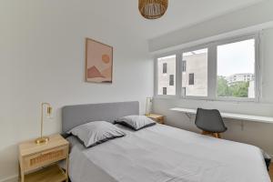 um quarto com uma cama, uma secretária e uma janela em CityStay full brand new appartement 3 bedrooms 5min to Paris em Bagnolet