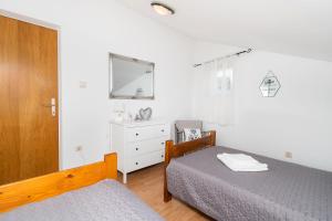 a bedroom with a bed and a dresser and a mirror at House Bany in Skradin