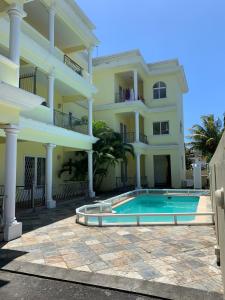 a large house with a swimming pool in front of it at Summersun Residence in Grand Baie