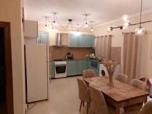 a kitchen with a table and a white refrigerator at Summersun Residence in Grand Baie