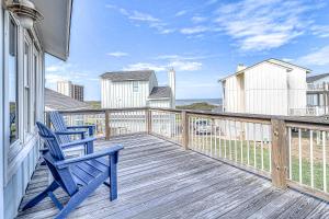ein Deck mit zwei blauen Stühlen darauf in der Unterkunft Lost Colony Shiny Shell Cottage in Port Aransas